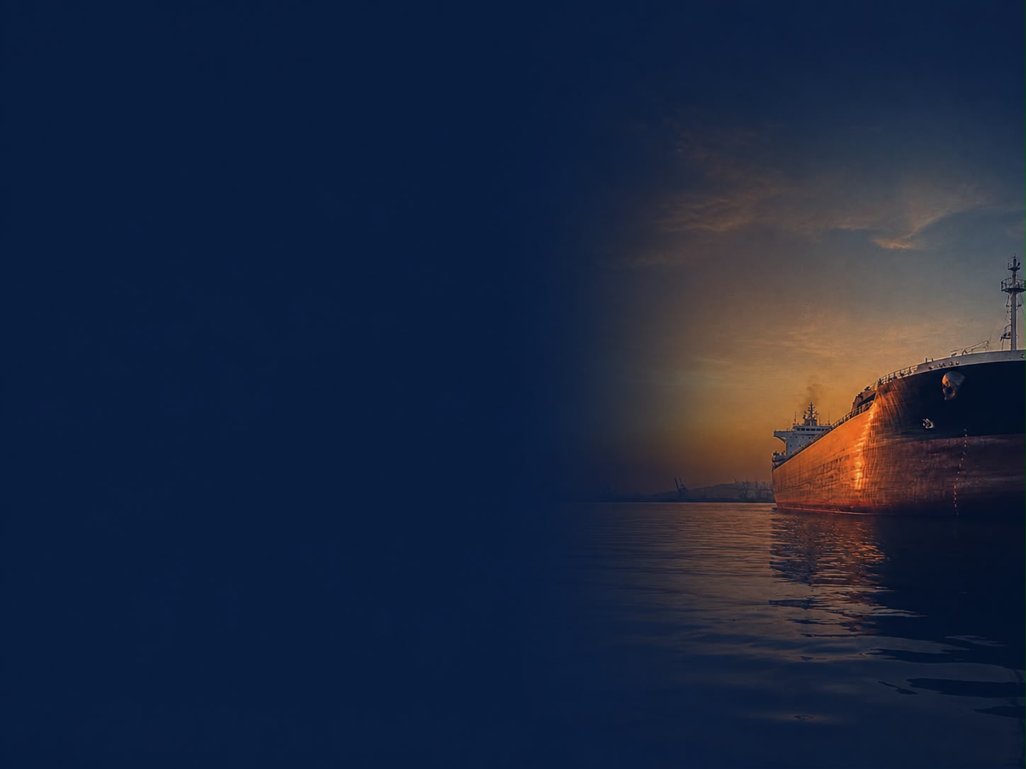 Container terminal at dusk with copper lights reflecting on wet quay